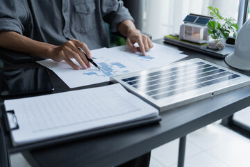 Fototapeta premium Electrical engineer working on solar panel blueprint sustainable energy