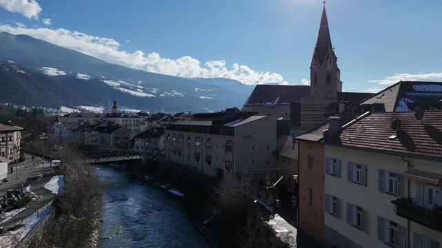 Descending Drone Flight from Bressanone Town and Cathedral Down to Alpine River, South Tyrol, Italy