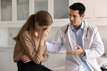 Naklejka premium Doctor offering friendly guidance and emotional reassurance to distressed woman patient in clinic during consultation. Supportive communication, compassionate care, negative health news, counseling