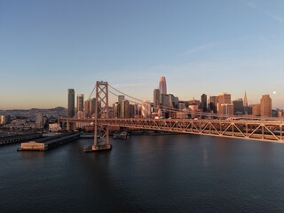 Fototapeta premium Aerial sunset view of San Francisco skyline and Bay Bridge with traffic over the bay, California cityscape at golden hour. g.