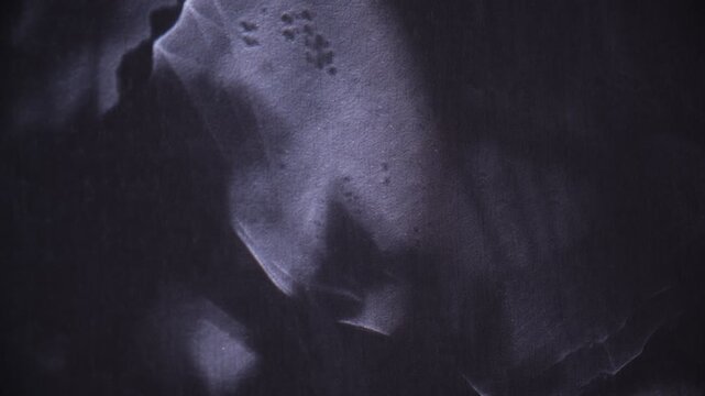 Textured wall, on which gleams of light cast fanciful shadows. The twilighty shadows danced across the dark background, grotesque twilight loomed against the wall. Surreal backdrop