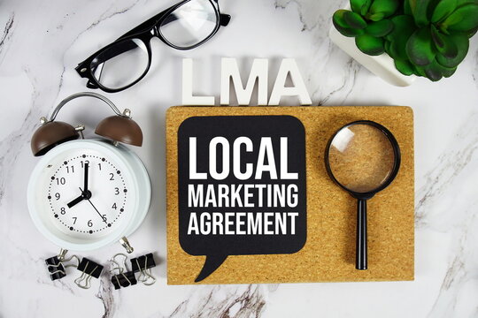 LMA - Local Marketing Agreement acronym with alarm clock and magnifying glass, Business concept background