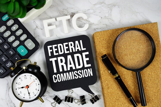FTC - Federal Trade Commission acronym with calculator, alarm clock and magnifying glass, Business concept background
