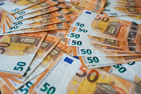 Wide composition of 50 euro bills spread randomly, representing financial abundance