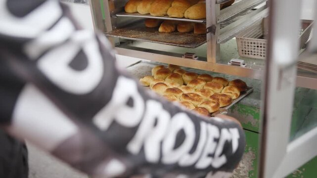 Street Vendor Arranging Freshly Baked Moringa Pandesal for Display at Street Stall