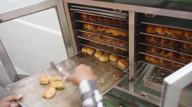 Street Vendor Arranging Freshly Baked Moringa Pandesal for Sale at Food Stall