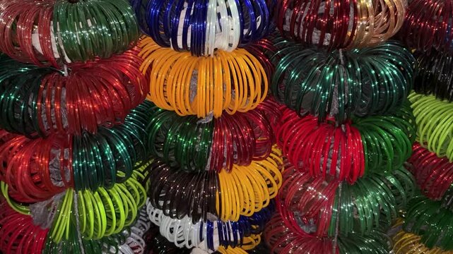 stacked colorful wrist bangles with glossy texture in indian bazaar shop