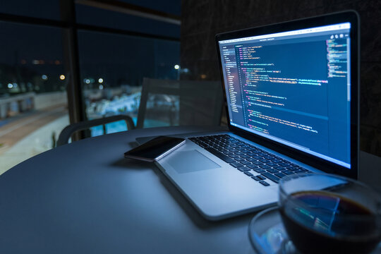 Working on code during the night at a modern space near a swimming pool