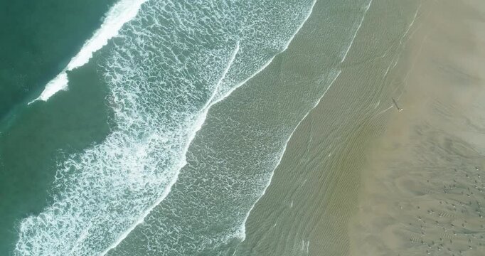 Aerial view of ocean waves washing onto sandy beach The Concept of summer vacation