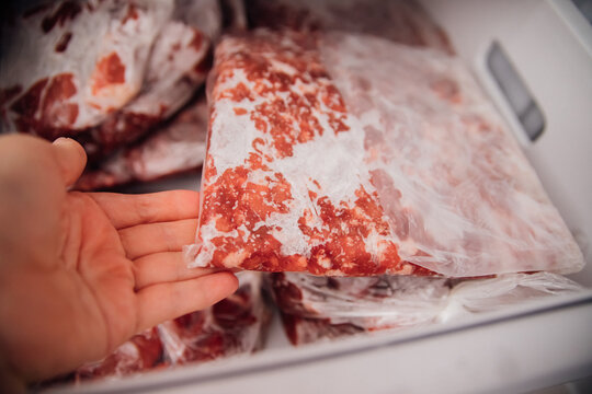 Various frozen beef cuts packed in bags inside the freezer. The concept of food preservation.