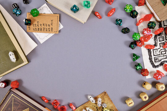 Tabletop role playing flat lay background with RPG dices, rule books, dungeon map and copy space in middle