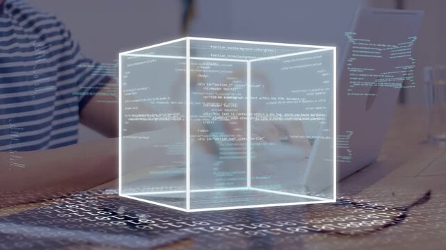 Man typing on laptop at desk, starting wireframe cube appearing growing rotating showing tech data