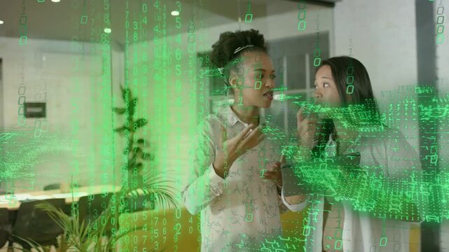 Two women tapping tablet gesturing and interacting with green overlay forming band for tech demo