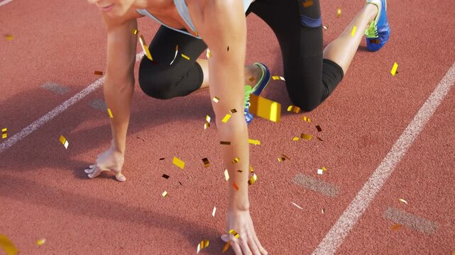Woman athlete shifting into sprinter crouch on track, confetti obscuring shoes for sports start