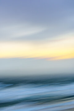Impressionist coastal scene of the sea, cloud and sun in gap at Ripiro Beach Northland New Zealand.