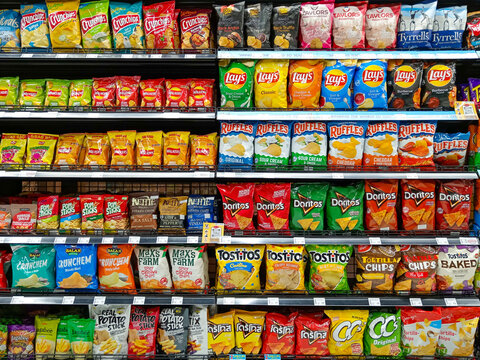 Bangkok, Thailand - February 16, 2026:  Full shelves at Villa Market in Bangkok show many brands of ultra processed junk food potato chips and unhealthy snacks.