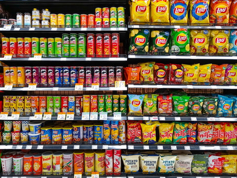 Bangkok, Thailand - February 16, 2026:  Full shelves at Villa Market in Bangkok show many brands of ultra processed junk food potato chips and unhealthy snacks.