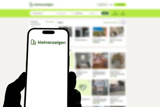 Kiel, Germany - 05-20-2026: Smartphone displaying the German online classifieds platform Kleinanzeigen app in the App Store in a workspace environment with laptop and notebook