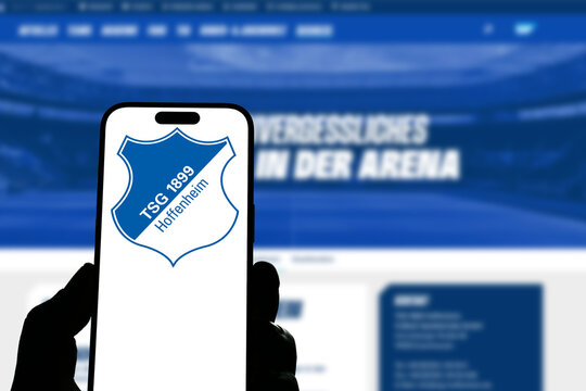 Kiel, Germany - 05-20-2026: Smartphone displaying the German football club TSG Hoffenheim app in the App Store in a workspace environment with laptop and notebook