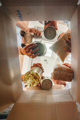 Volunteers putting food in a donation box for charity