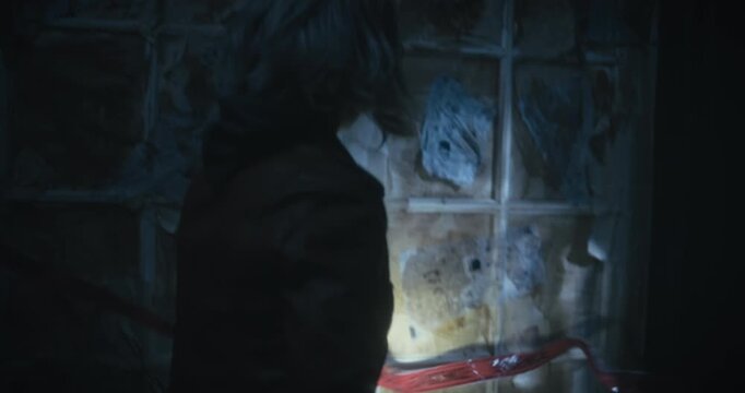 Silhouette of woman with flashlight as she removes red evidence tape - medium, steady cam shot