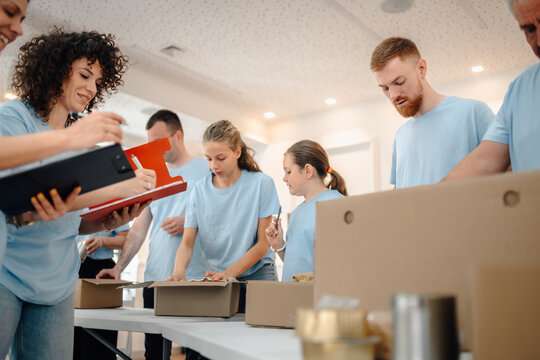 Volunteers sorting and packing donation boxes for charity