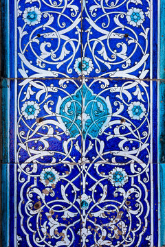 Ornate blue and white ceramic tilework with floral arabesque pattern from Islam Khoja Madrasah in Khiva. Ideal for cultural heritage, travel, design publications. Tile texture, pattern, background.