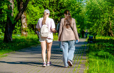 Obraz premium Two girlfriends walk along a path in the Park 