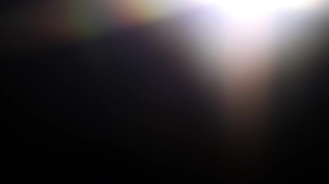 Real optical light leak with soft amber and golden haze in the corner of a black frame. Subtle organic glow transition overlay for cinematic video compositing and minimal motion background.