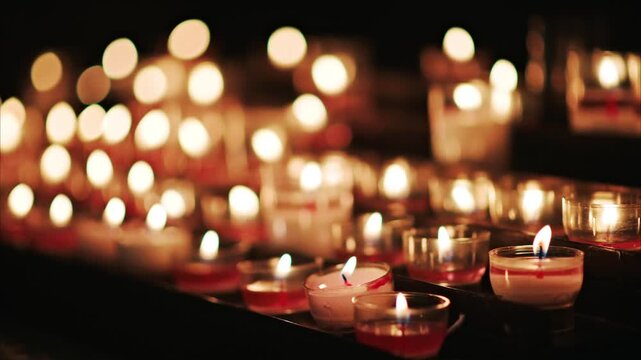 Candle lights in a row creating a peaceful and spiritual ambiance, flickering gently in dark church.
