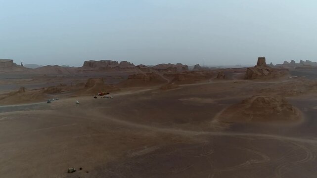 Isolated yardang formation stands alone in vast desert plain under overcast sky with wind-eroded textures creating minimalist natural rock scene ideal for geology and arid landscape stock video