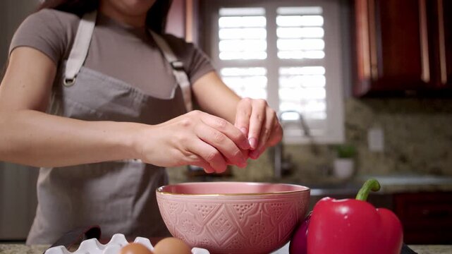Woman prepares to make an omelette with vegetables