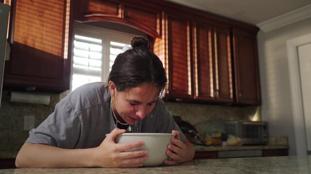 Woman dunks face into ice water as part of skin care routine in slow motion