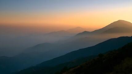 Obraz premium Misty mountain landscape bathed in the warm glow of golden hour during sunrise creating a serene and adventurous atmosphere