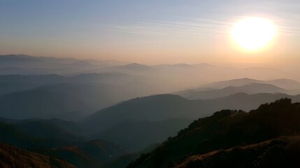 Obraz premium Misty mountain range bathed in warm golden light during the tranquil morning hours