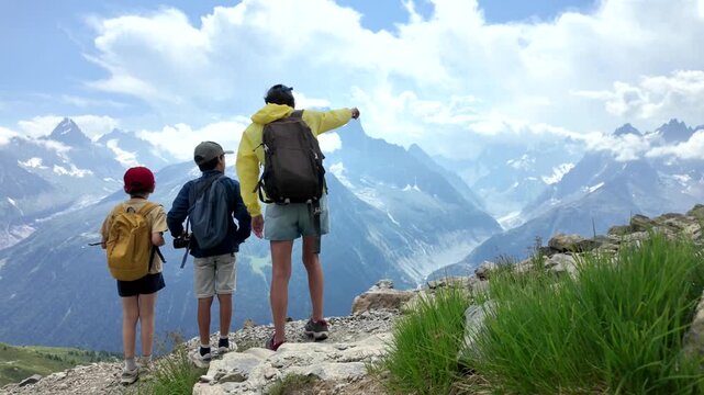Mother with her two sons hiking on a mountain trail and enjoying the scenic view of the mont blanc massif with its stunning peaks, glaciers, and breathtaking landscape