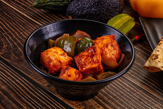 Indian Paneer Tikka Masala inl with Roti bread on a dark wooden table