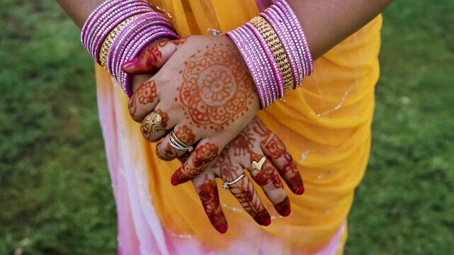 indian woman hands with traditional mehndi design and colorful bridal bangles
