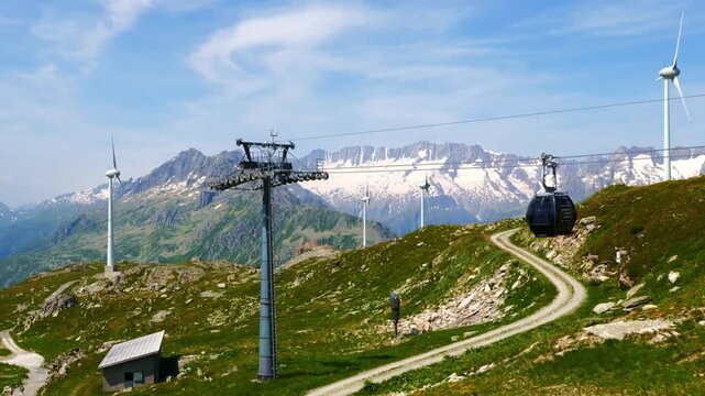 Beautiful Mountain View with a Glacier and Wind Turbine and Overhead Cable Car in the Swiss Alps in a Sunny Summer Day in Andermatt, Uri, Switzerland.