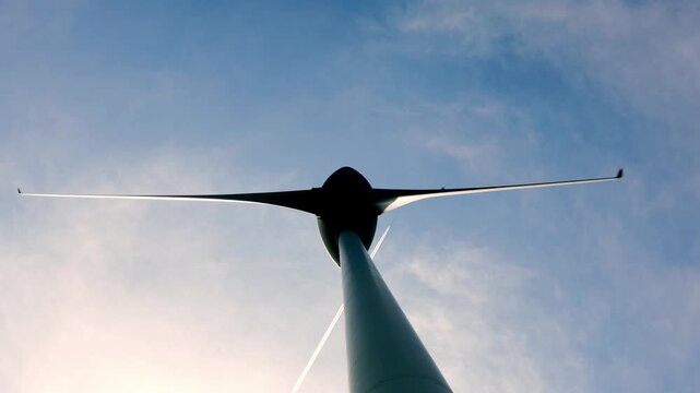 Directly Below on a Wind Turbine Against Blue Sky with Clouds in a Sunny Summer Day in Andermatt, Uri, Switzerland.