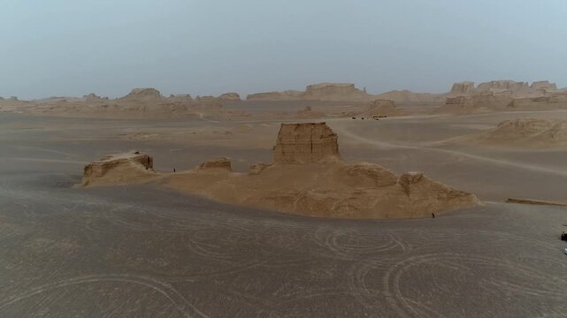 Isolated yardang rock formation in empty desert under hazy sky with wind erosion creating minimalist natural scene perfect for geology and wilderness stock video footage.