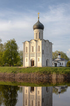 Historic Church of the Intercession on the Nerl reflected in calm river water at sunset