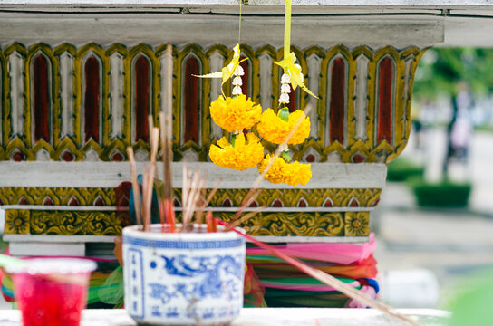 Traditional Thai spirit house altar with marigold garlands and incense in Bangkok, Thailand, 2012