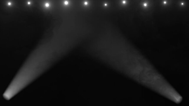 Dynamic moving searchlights sweeping side to side over floating stage vapor, cinematic light effect 4K