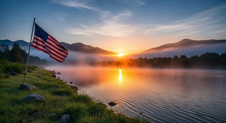 Fototapeta premium American flag waves proudly over misty lake at sunrise in mountains, serene natural landscape with sun rays.