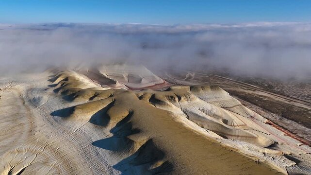 The colorful Kyzylkup Canyon in the clouds is a natural landmark in Kazakhstan's Mangystau region. A group of colorful hills with multi-layered slopes reminiscent of the Italian dessert tiramisu