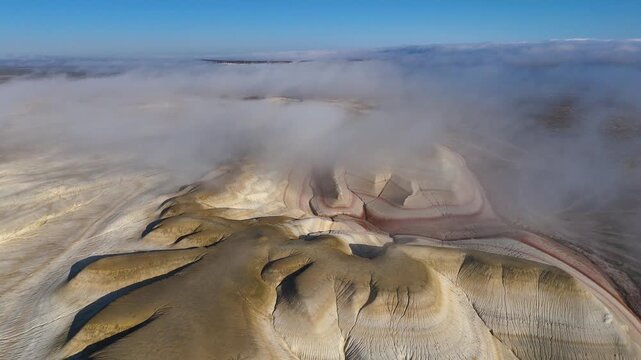 The colorful Kyzylkup Canyon in the clouds is a natural landmark in Kazakhstan's Mangystau region. A group of colorful hills with multi-layered slopes reminiscent of the Italian dessert tiramisu