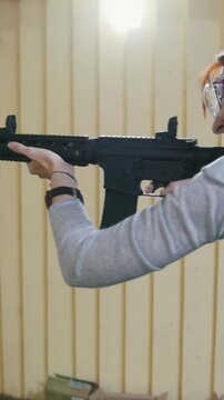 Woman shooting with a Mashin gun in shooting gallery