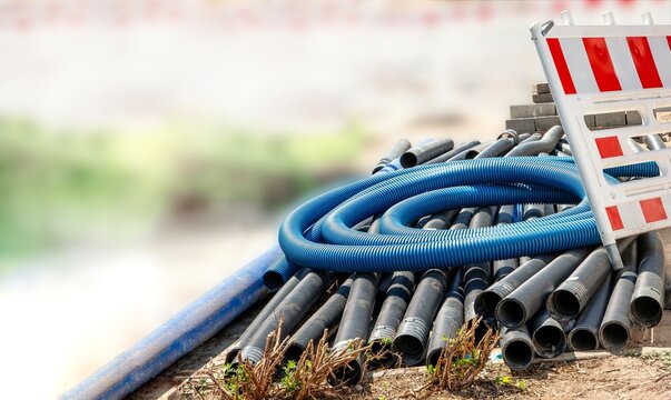Corrugated plastic pipes and construction barrier at a construction site