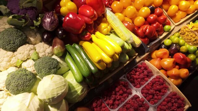 Fresh seasonal produce display featuring tomatoes zucchini, corn, raspberries